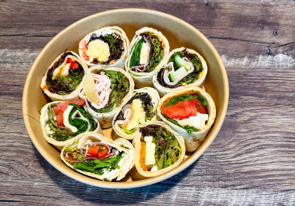 Bäcker-Sushi 10er-Pack von Brotzeit Rostock — zehn herzhafte Röllchen aus Fladenbrot mit Salat, Gemüse und wechselndem Belag in einer Schale